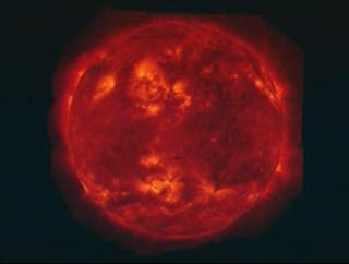 Zoom in to the Bastille Day flare (1998) and fade to a model of the magnetic field lines in the region.