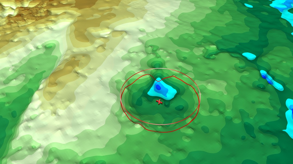 As this visualization draws near to the northwest coast of Greenland where the Hiawatha Glacier is located, the ice sheet is cut away to show the topography of Greenland's bedrock lying beneath the ice sheet at 20x vertical exaggeration. The Hiawatha crater is clearly visible in the topography. Farther inland another, subtler circular depression can be seen. The edge picks of this depression are shown as vertical bars, while potential central peaks are marked by orange pyramids. As we rotate around the depression, the location of the best-fit circle to the edge picks appears and that circle's center is marked with an "X". This circle matches well with both the edge of the bedrock depression and also the residual slope of the ice surface as it flows over this depression (not shown), strongly supporting the inference that this depression is another large impact crater.This video is also available on our YouTube channel.