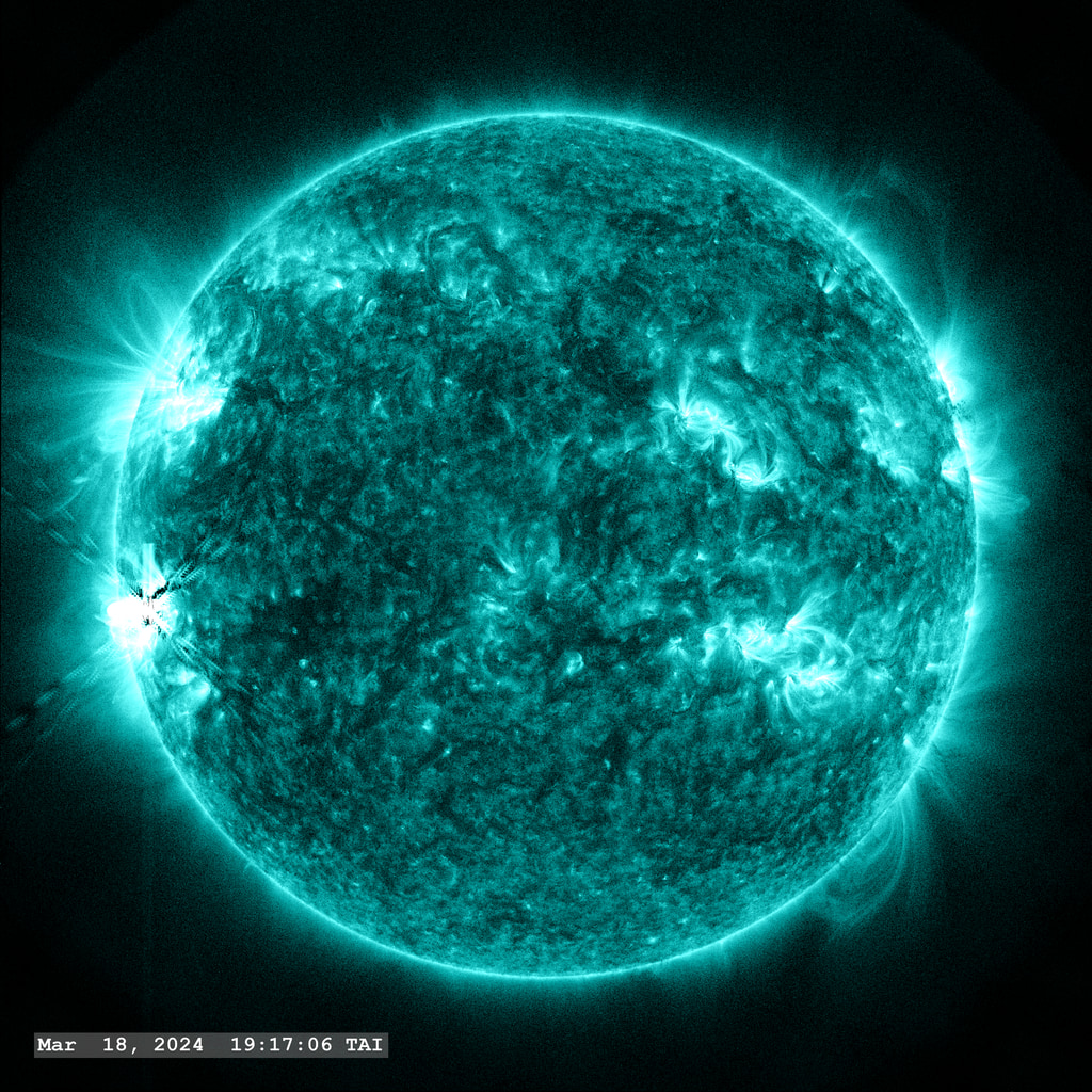 An M6.7 flare erupts from Active Region 13615 in the lower left quadrant of the image in this view from SDO/AIA 131 angstrom filter. The point-spread function correction (PSF) has been applied to all this imagery.