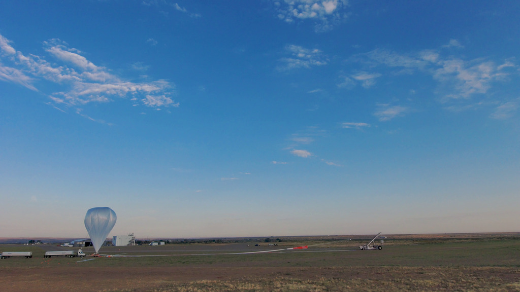 Drone imagery showing the launch of HASP 2.0 from Fort Sumner on Aug. 28, 2024. Credit: NASA/Francis ReddyVideo playback is at half speed (30 fps). At 0:11, the inflated balloon rises vertically, gradually reaching its full height by 1:49. The camera turns to keep it centered in the frame as the launch vehicle holding the payload maneuvers. 2:14 The launch collar, a device that holds the balloon film together following its initial release, slowly tumbles to earth. 2:38 The payload is launched, the balloon climbs into a blue sky peppered with a few clouds, and the camera rises, tilts, and rotates to follow it.   